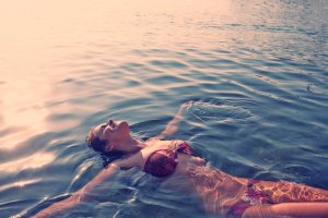 Young woman relaxing and swimming in water